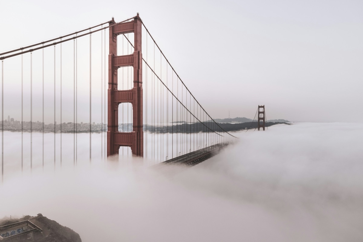 The Golden Gate Bridge emerging from pale fog
